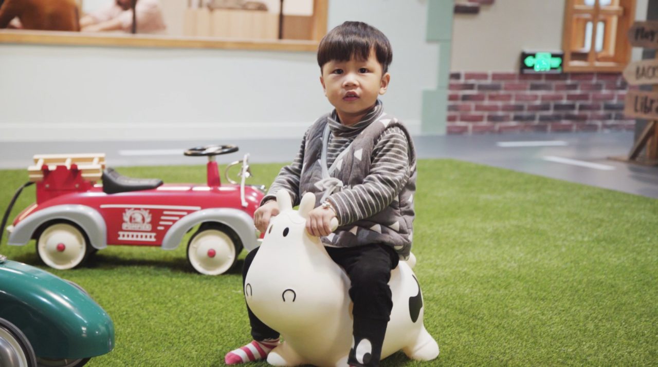 Little boy rides on a plastic cow toy